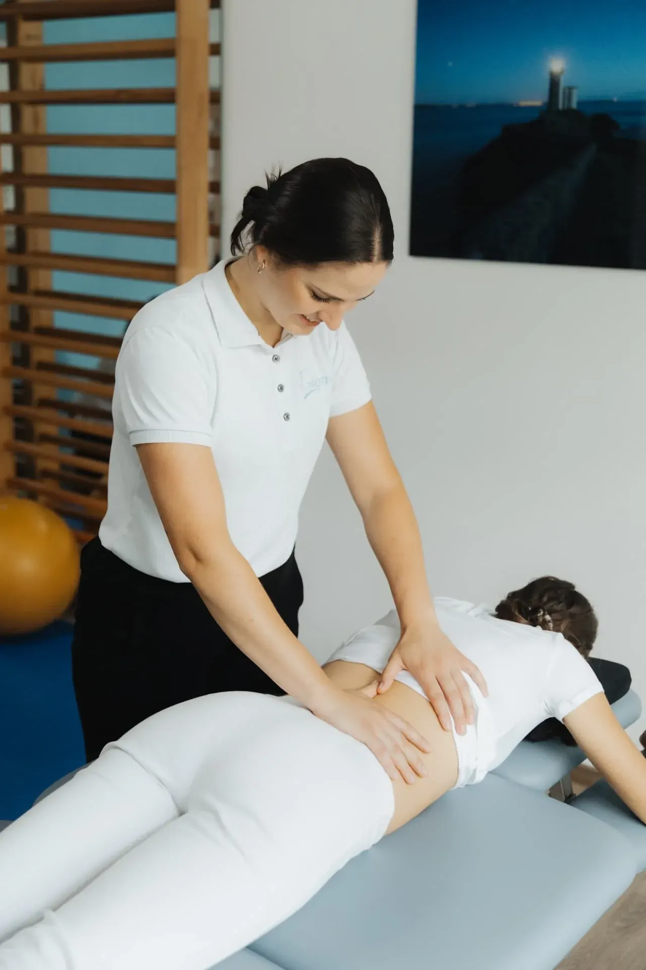 Therapeutin behandelt den Rücken einer Patientin in der Praxis Eden Physiotherapie München
