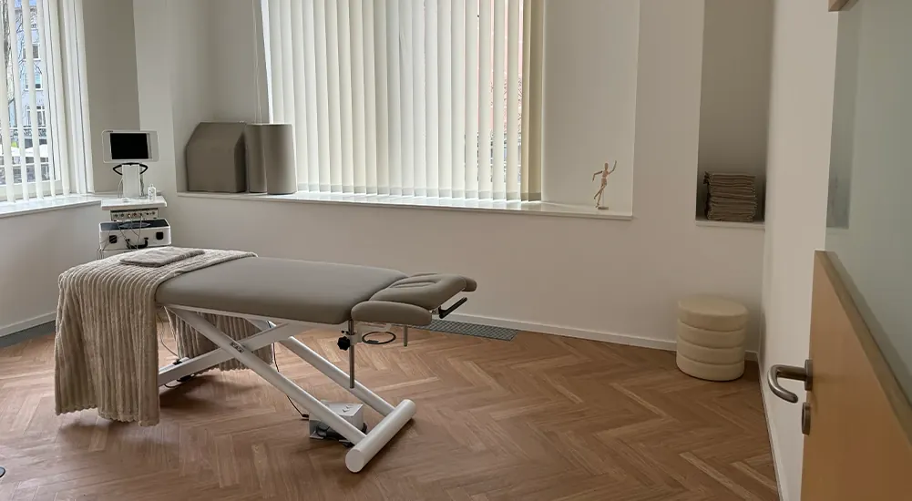 Heller Behandlungsraum mit Therapieliege in München