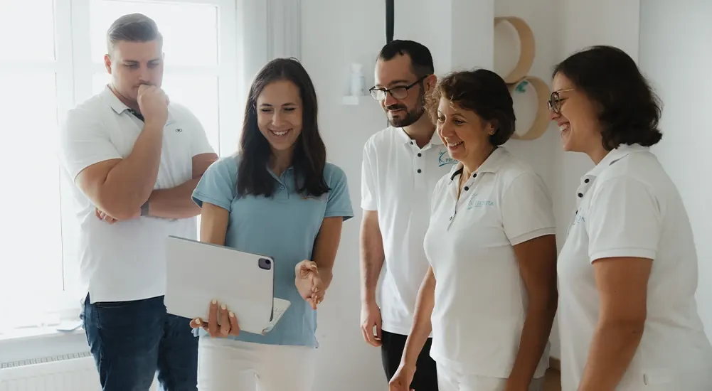 Kolleginnen und Kollegen von Eden Physiotherapie besprechen sich mit einem Laptop